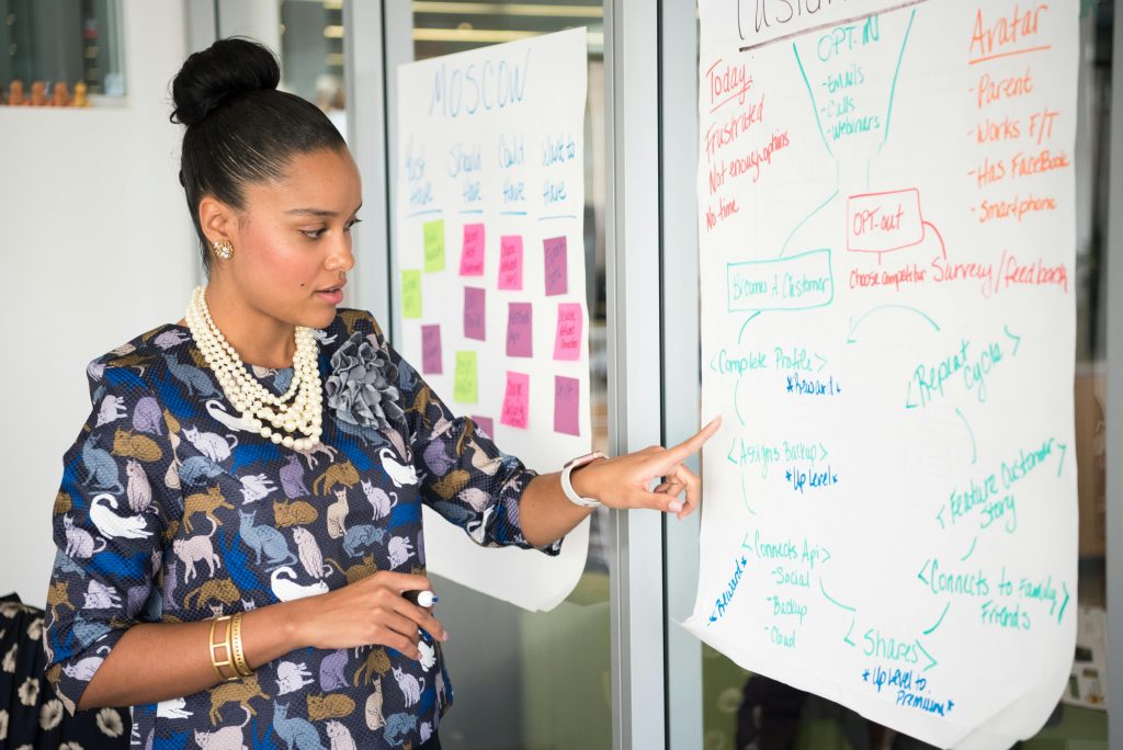 Professional woman presenting business strategy on paper in office. Engaged in workplace discussion.