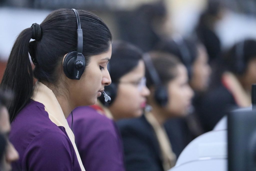 Call center agents wearing headsets working in a focused office environment.