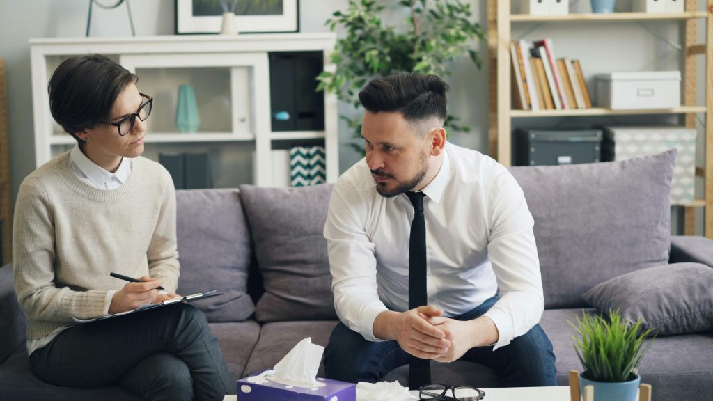 A therapist and client engage in counseling session, discussing personal concerns.