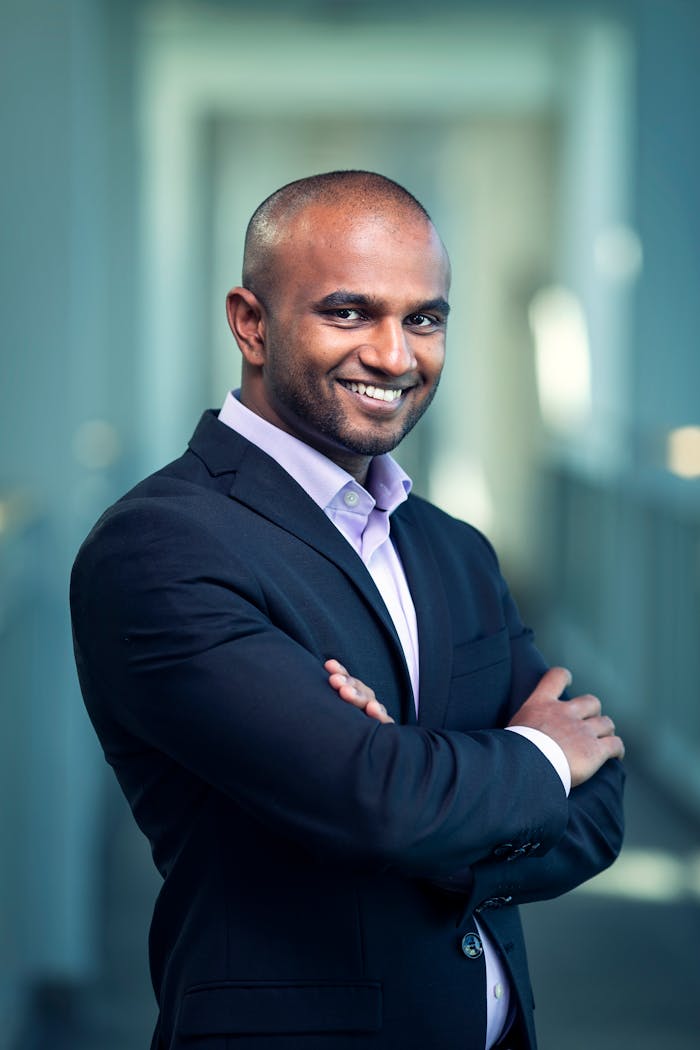 Portrait of a confident businessman in a suit, smiling and posing indoors.