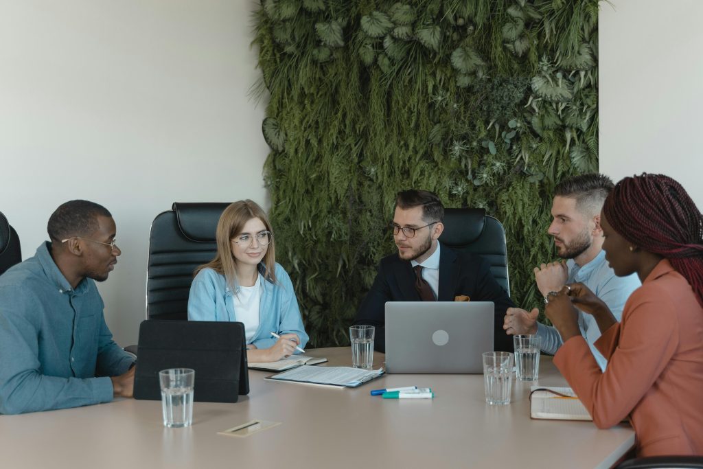 A group of diverse professionals discussing a project in a modern office setting.