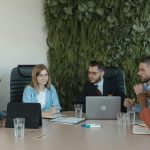 A group of diverse professionals discussing a project in a modern office setting.