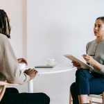 A professional job interview between a man and woman in a modern office setting.