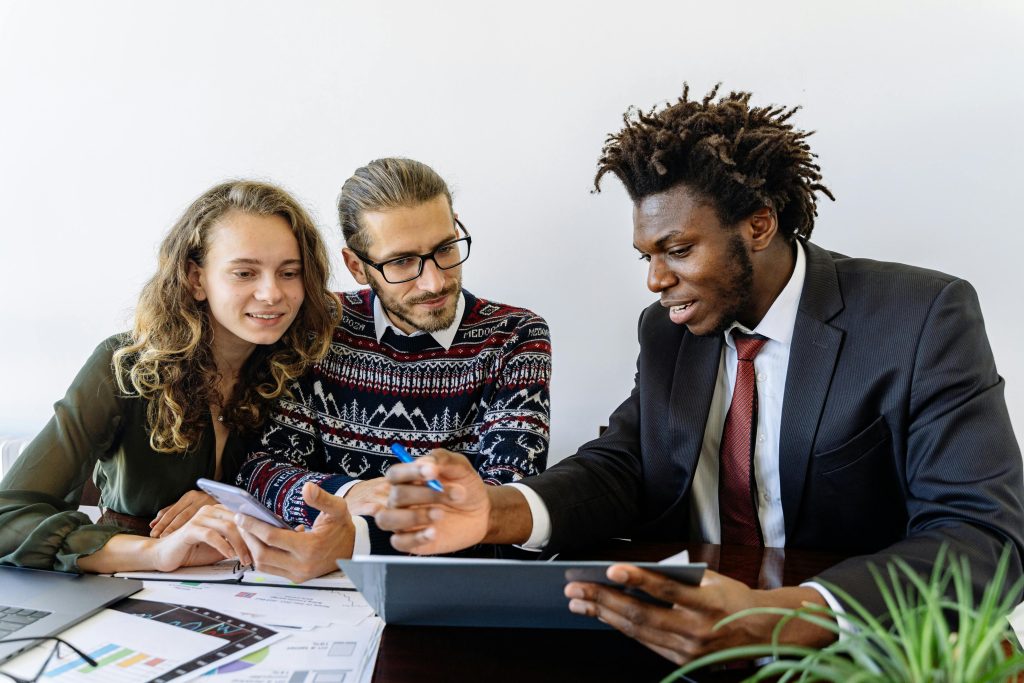 Three professionals engaging in a collaborative business meeting in a modern office environment.