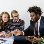 Three professionals engaging in a collaborative business meeting in a modern office environment.