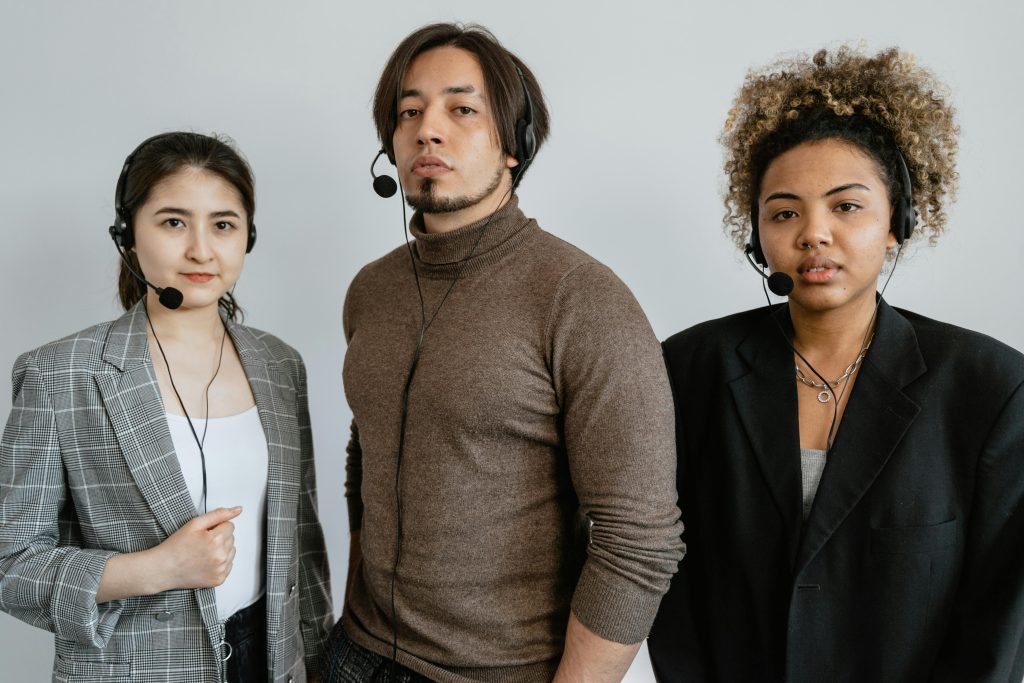 A diverse team of customer support professionals wearing headsets in an office setting.