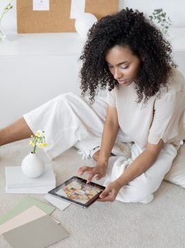 Creative woman using a tablet for design planning in a modern, relaxed setting.